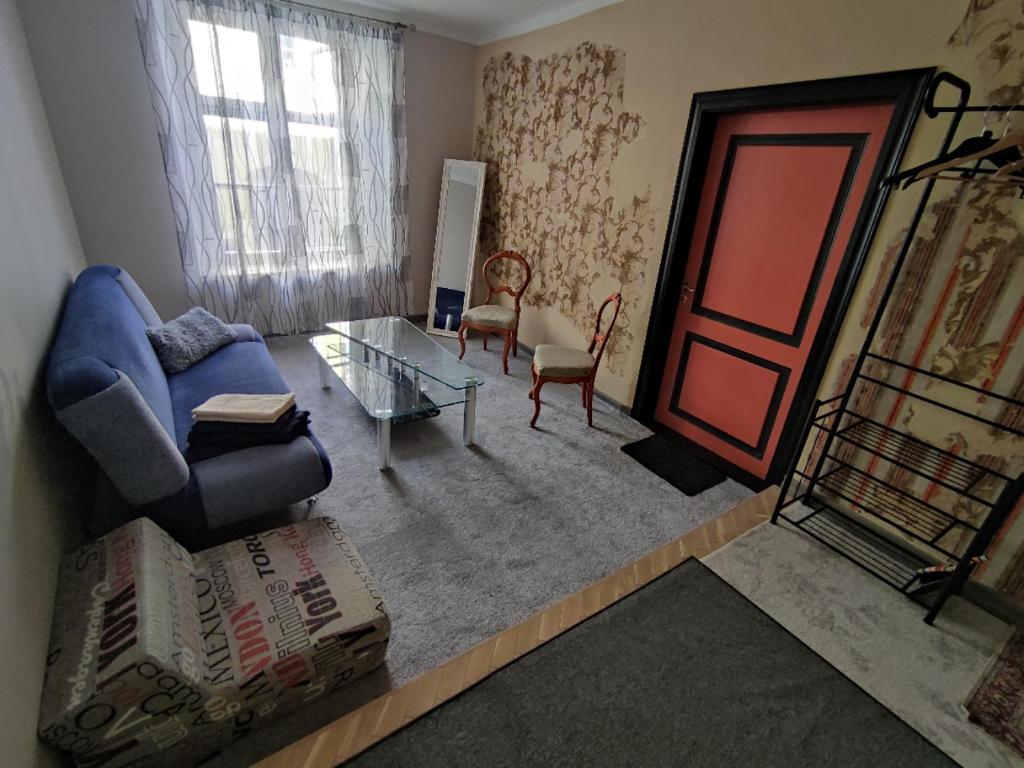 un salon avec un canapé bleu et une table en verre dans l'établissement Budget nest, à Toompea