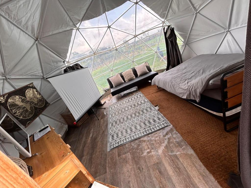 una camera da letto in una tenda a cupola con letto e scrivania di Secret Heated Dome, Hot Tub,Firepit Projector in Lincoln a Lincoln