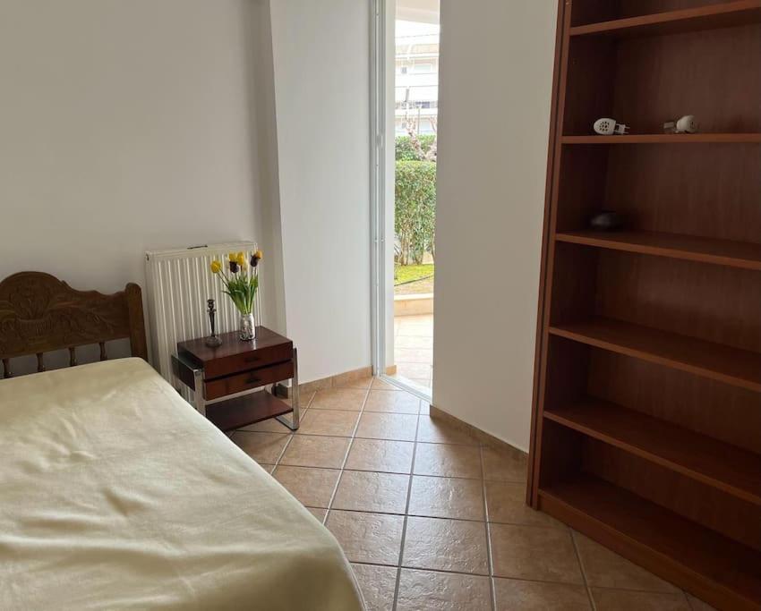 a bedroom with a bed and a table with a vase of flowers at Seafront Porto Rafti, 95 sq m close to airport, garden in Agios Spyridon
