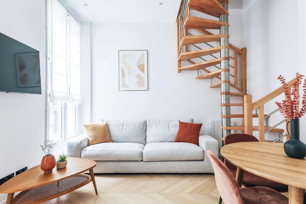 un salon avec un canapé et une table dans l'établissement Urban Retreat Brand-New Duplex 2-Bedroom, à Paris