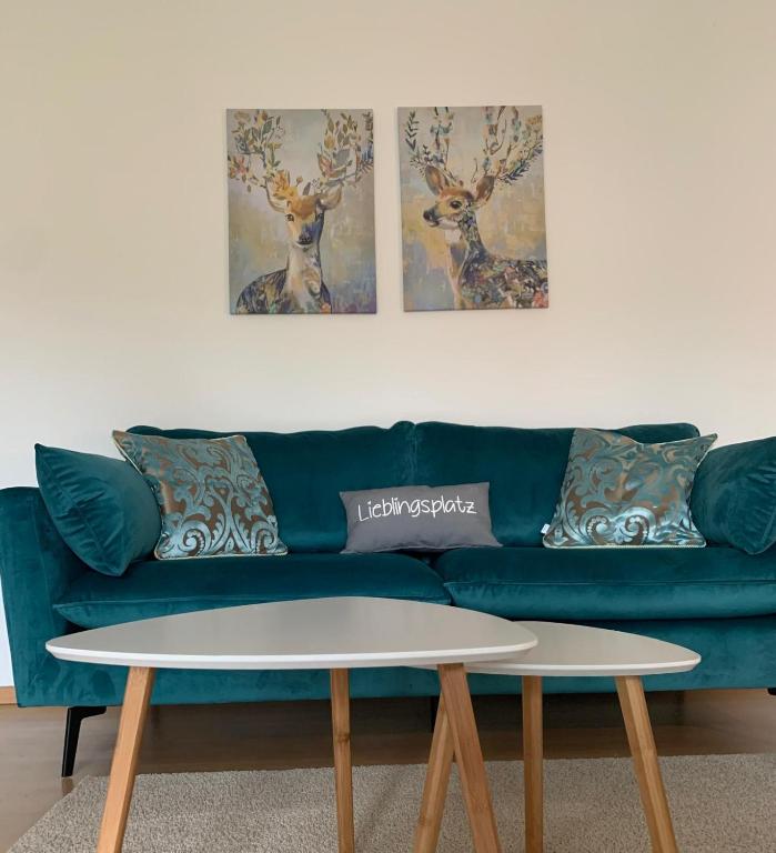 a living room with a blue couch and two paintings at Wiedenbrück Zentrum schöne Wohnung mit Balkon-8- in Rheda-Wiedenbrück