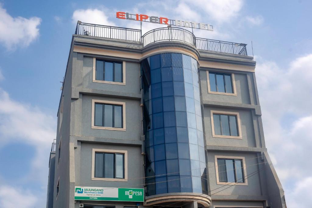 a building with a sign on top of it at Eliper Hotel in Gatura