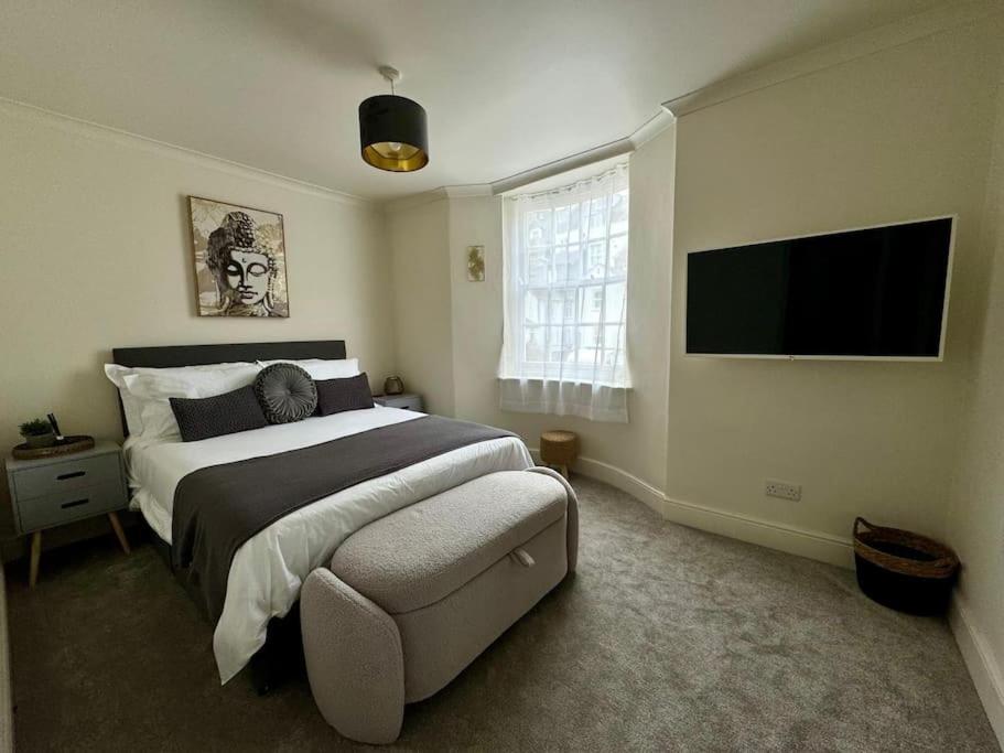 a bedroom with a bed and a flat screen tv at Townhouse in Weymouth, Dorset in Melcombe Regis