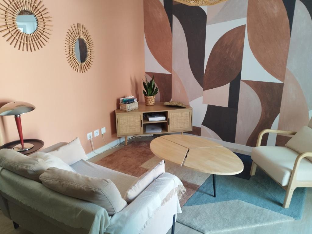 un salon avec un canapé et une table dans l'établissement La petite Madeleine, à La Rochelle