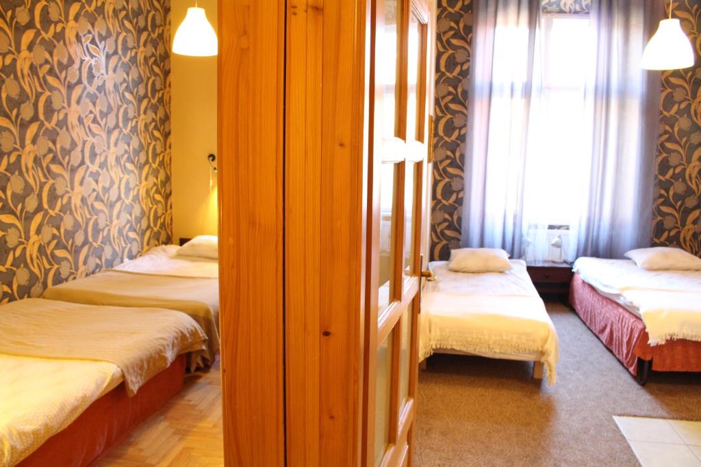 a room with two beds and a window at Cracow Old Town Guest House in Krakow