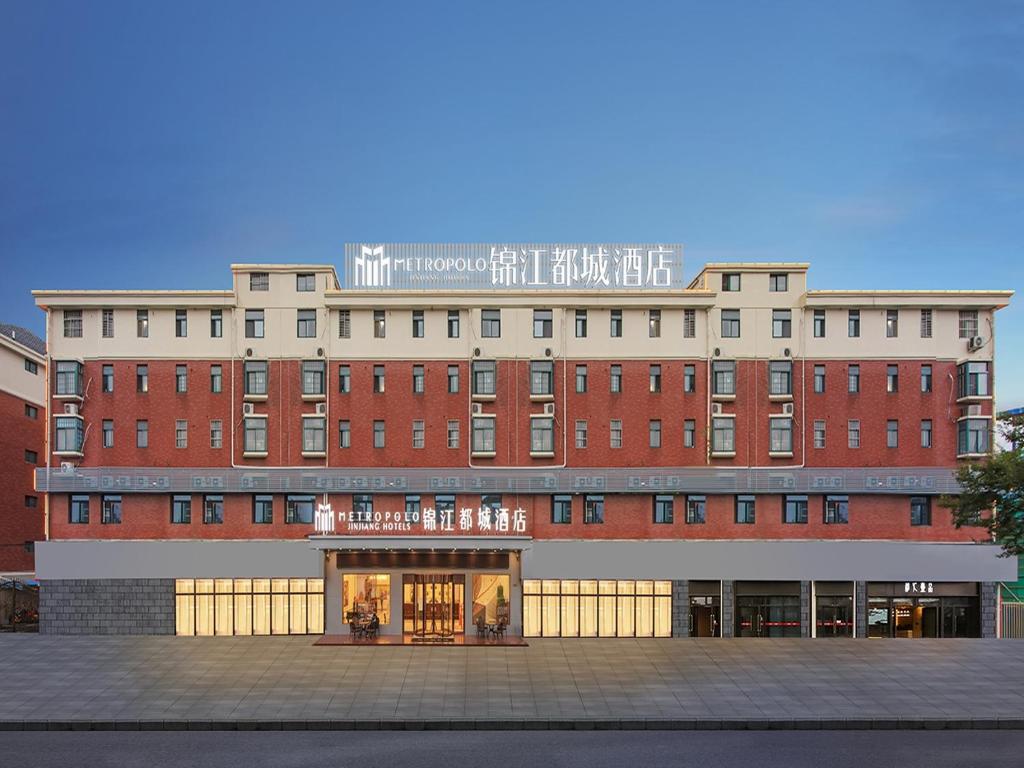 duży budynek z czerwonej cegły z napisem w obiekcie 锦江都城 新沂行政中心北京路店 w mieście Xinyi