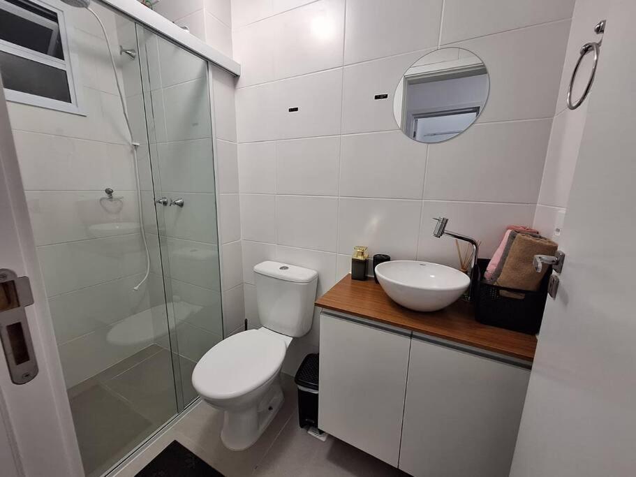 a bathroom with a toilet and a sink and a shower at Apartamento Paris in São José dos Pinhais
