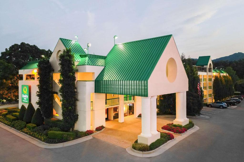 a house with a green roof in a parking lot at Quality Inn Near the Island Pigeon Forge in Pigeon Forge