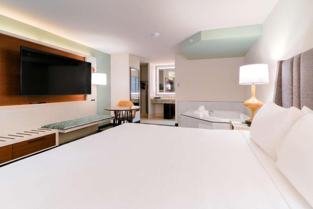 a bedroom with a large white bed with a flat screen tv at Quality Inn Near the Island Pigeon Forge in Pigeon Forge