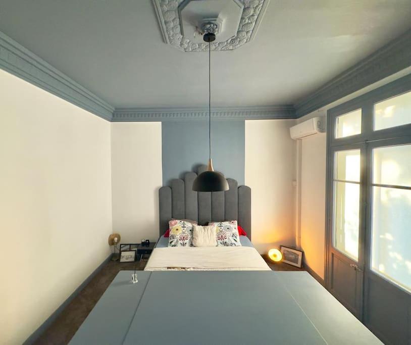 - une chambre avec un lit doté d'une grande tête de lit dans l'établissement Grand appartement hyper-centre, à Narbonne