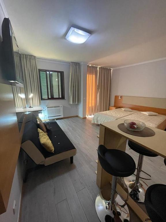 a hotel room with a bed and a desk and a table at Estúdio Costinha - Madeira in Garajau