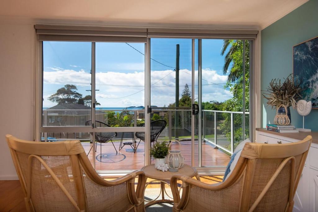 a living room with a balcony with a table and chairs at Azure Sands Ocean Views in Batehaven in Batehaven