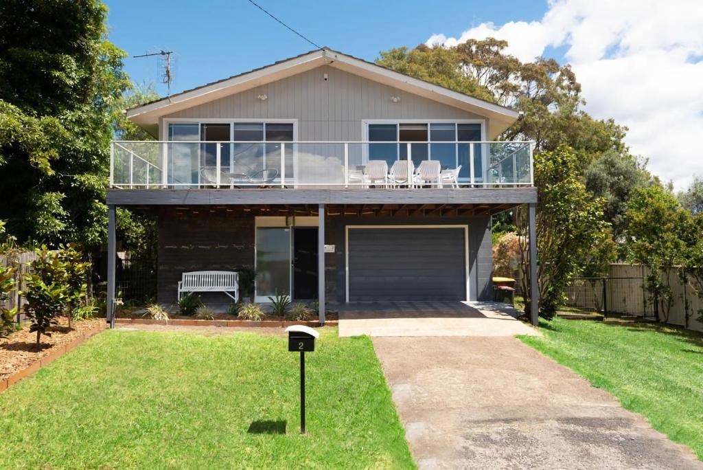 ein Haus mit einem Balkon darauf in der Unterkunft Beach House Ocean Views in Batehaven in Batehaven