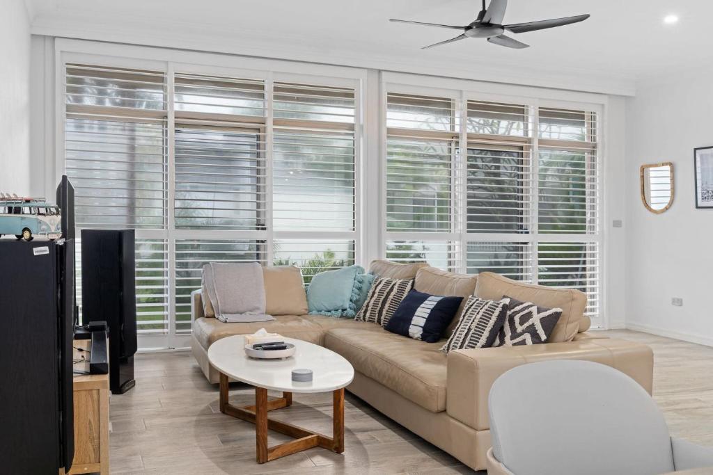 una sala de estar con un sofá y una mesa en Blissful Direct Beach Access Pet-Friendly, en Blue Bay 