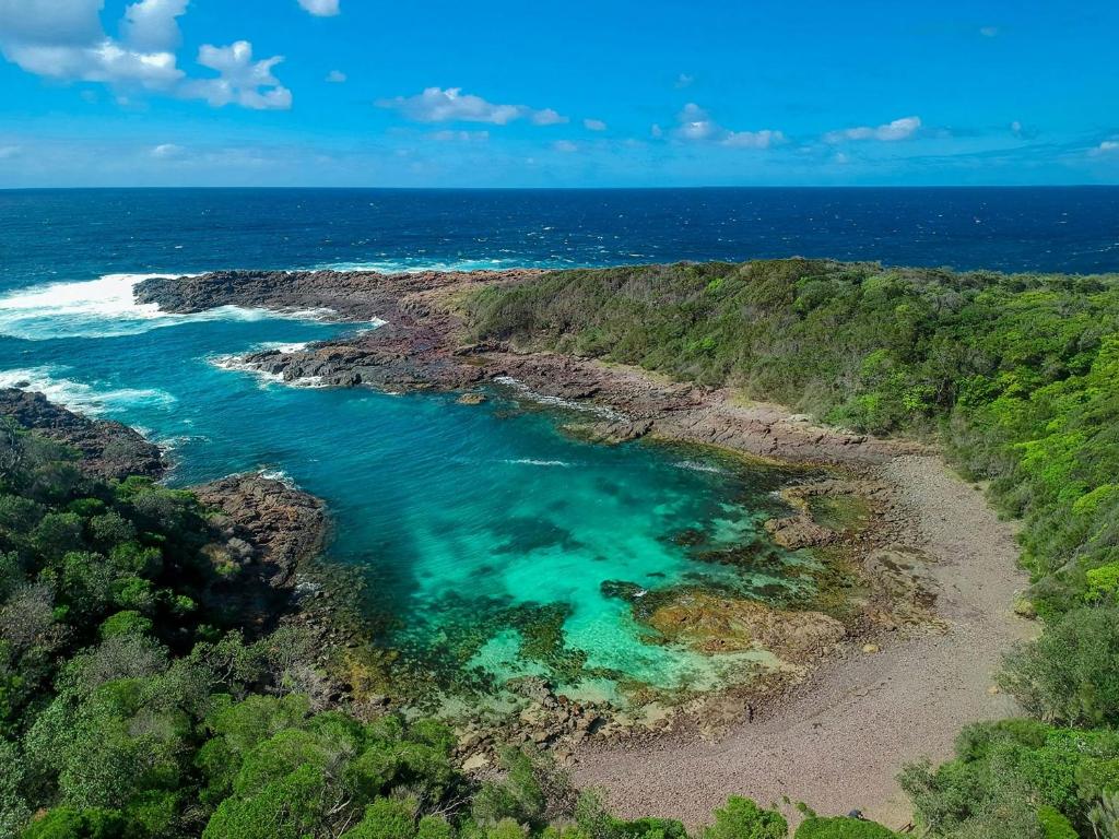 an aerial view of a beach with turquoise water at Coastal Delight In Shellcove in Dunmore