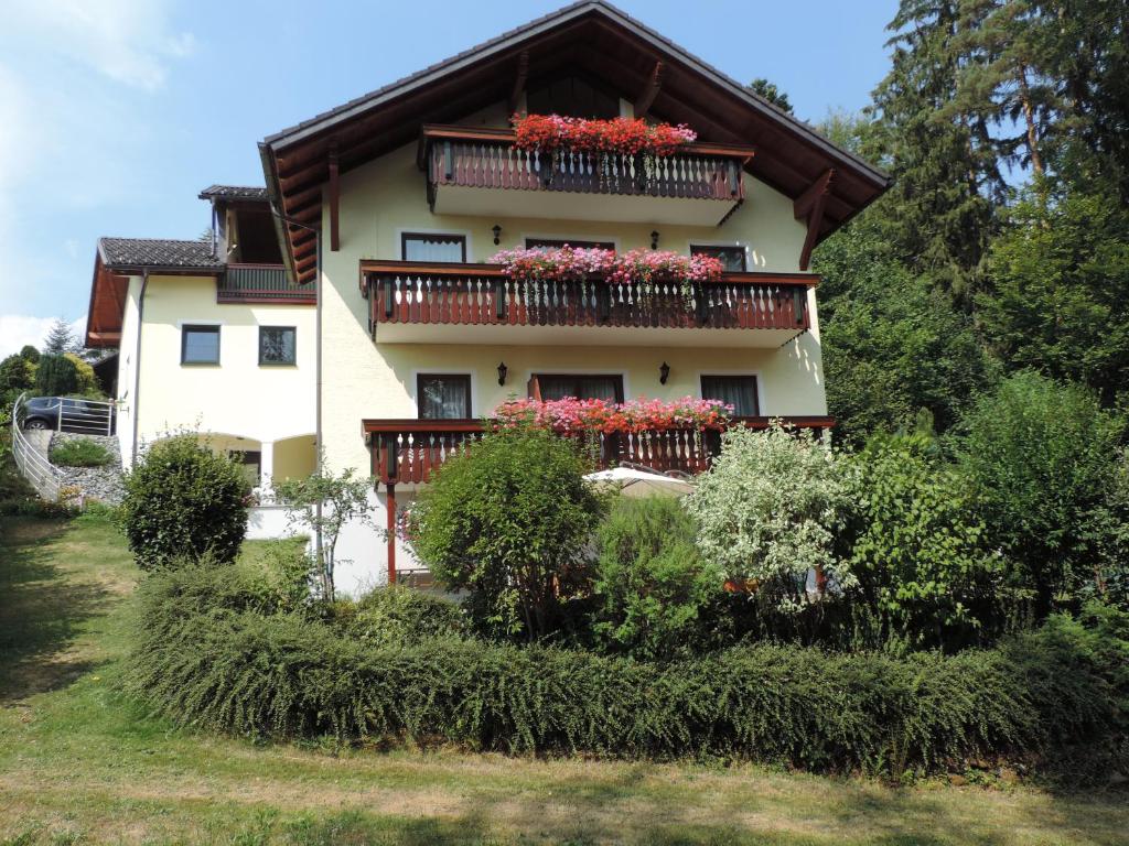ein Haus mit Blumenkästen auf den Balkonen in der Unterkunft Ferienwohnung Waldoase am Fuchsenstein in Spiegelau