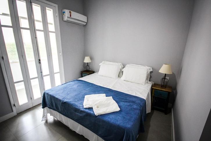 1 dormitorio con 1 cama grande con manta azul en Copacabana Best Deal Guest House, en Río de Janeiro