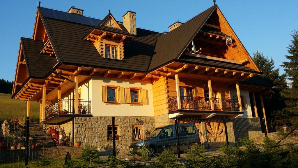 a house with a car parked in front of it at Apartamenty u Kukuca in Szczawnica
