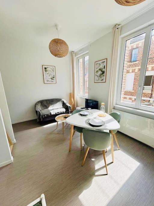 un salon avec une table et des chaises dans l'établissement Appartement Lumineux & Confortable, à Saint-Quentin