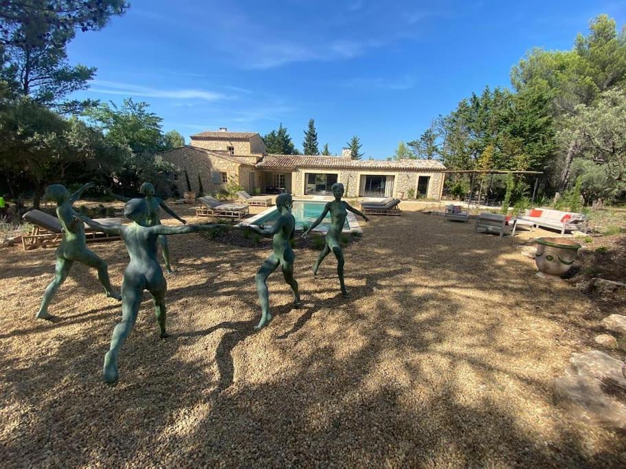 Une statue de quatre hommes jouant au football dans une cour dans l'établissement Domaine Farandole, à Eygalières