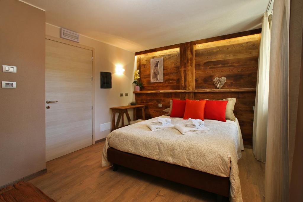una camera da letto con un letto con cuscini rossi di Serendipity Hotel a Sauze d'Oulx