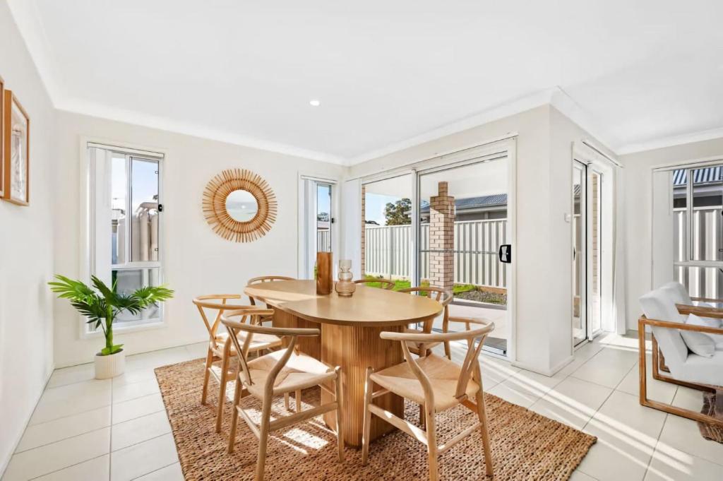 a dining room with a table and chairs at Sea La Vie One - Salt Air & Sunsets in Salamander Bay