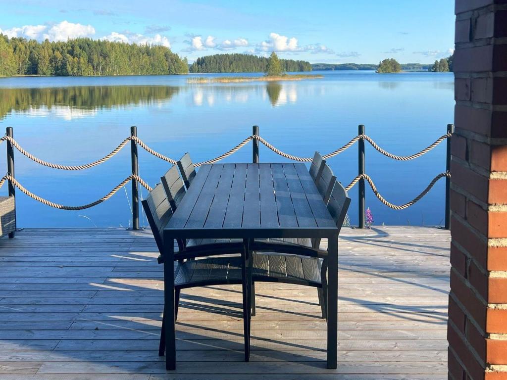 une table et une chaise bleues installées sur un quai près d'un lac dans l'établissement Holiday Home Brofeldt by Interhome, à Tohmajärvi