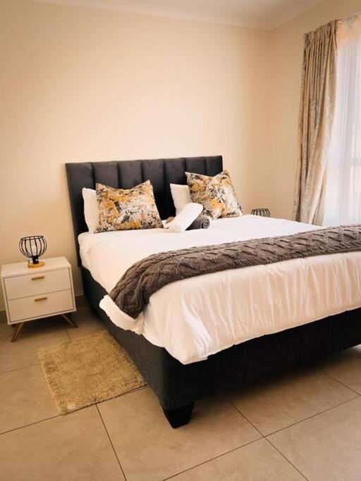 a bedroom with a large bed with a black headboard at Tetani's Luxury Oasis in Lakeside