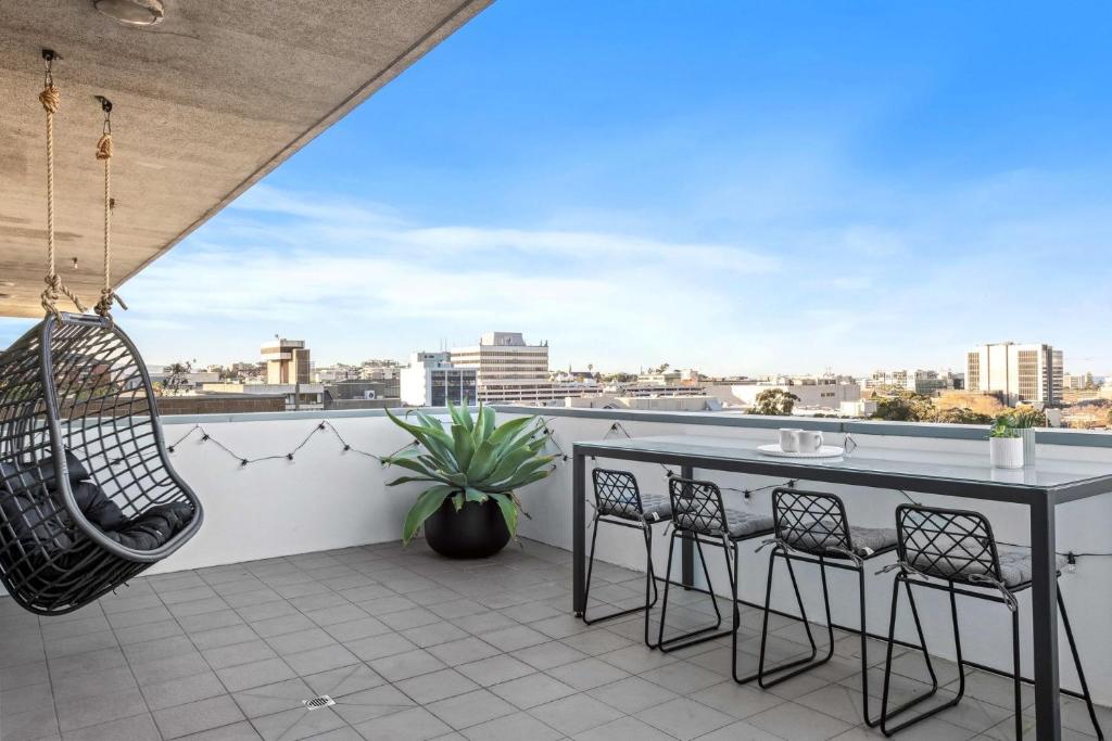 a balcony with a table and chairs at The Perch Gorgeous 3 Bedroom Penthouse in Wollongong