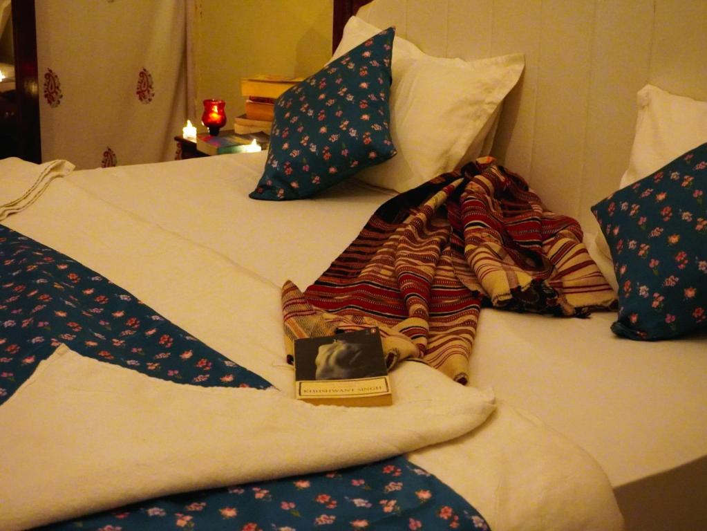 un letto con cuscini e un libro sopra di Dune Delite Jaisalmer a Sām