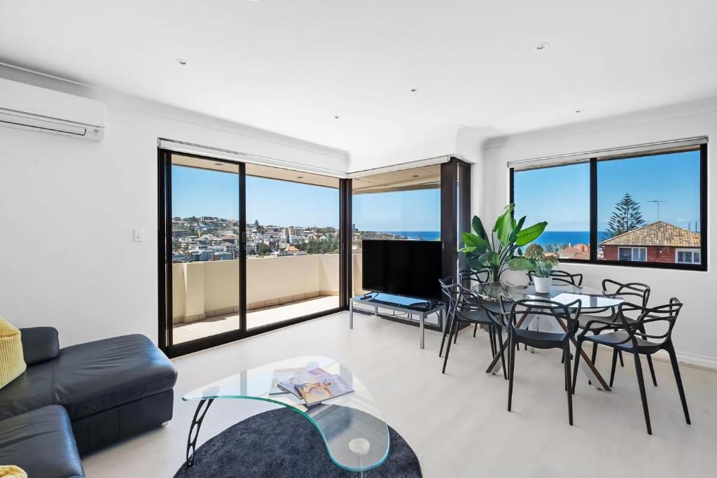 a living room with a couch and a table and chairs at Dream View Steps from the Beach in Sydney