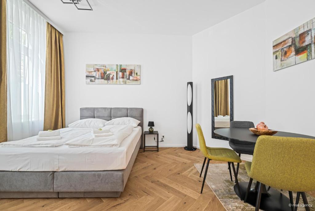 a bedroom with a bed and a table and chairs at easy-flat Rokitanskygasse - Apartments near Tram 43 to City Center in Vienna