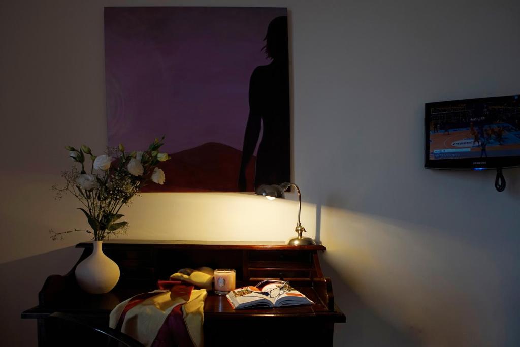 a bedroom with a bed and a vase of flowers on a table at Venere B&B in Catania
