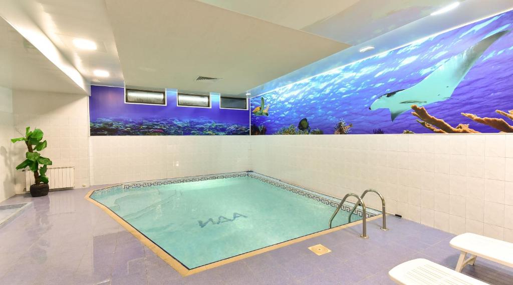 a swimming pool in a room with an aquarium at Hotel Ida in Bansko