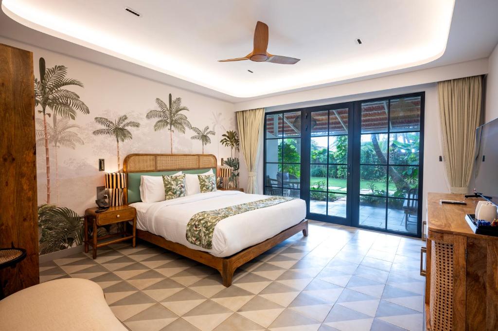 a bedroom with a bed and a sliding glass door at Palma Beach Resort in Mandrem