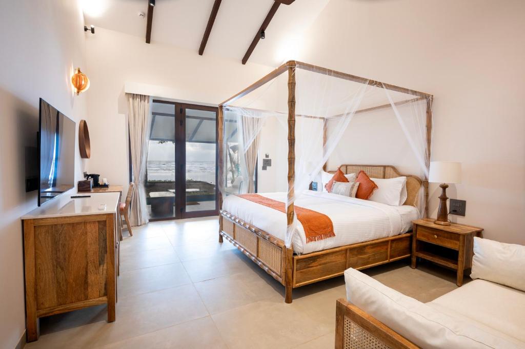 a bedroom with a canopy bed and a couch at Palma Beach Resort in Mandrem