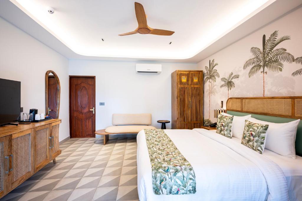 a bedroom with a large bed and a television at Palma Beach Resort in Mandrem