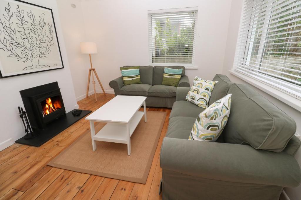 a living room with a couch and a fireplace at Bod A Quinte in St Ives