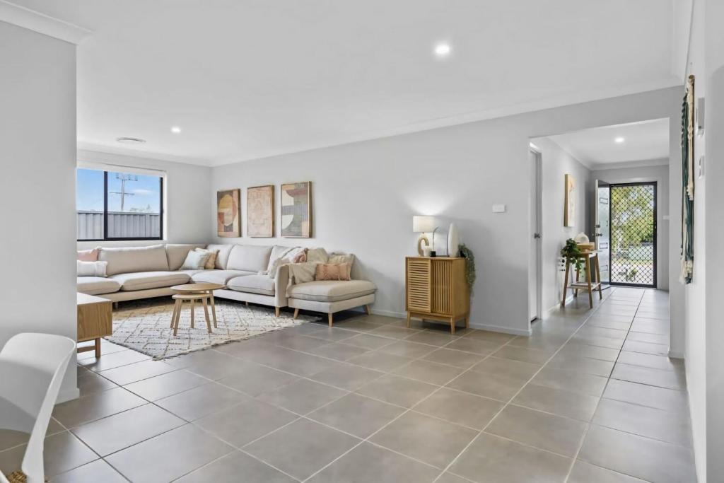 un soggiorno con un divano e un tavolo di Time Out Beautifully decorated new home a Cessnock