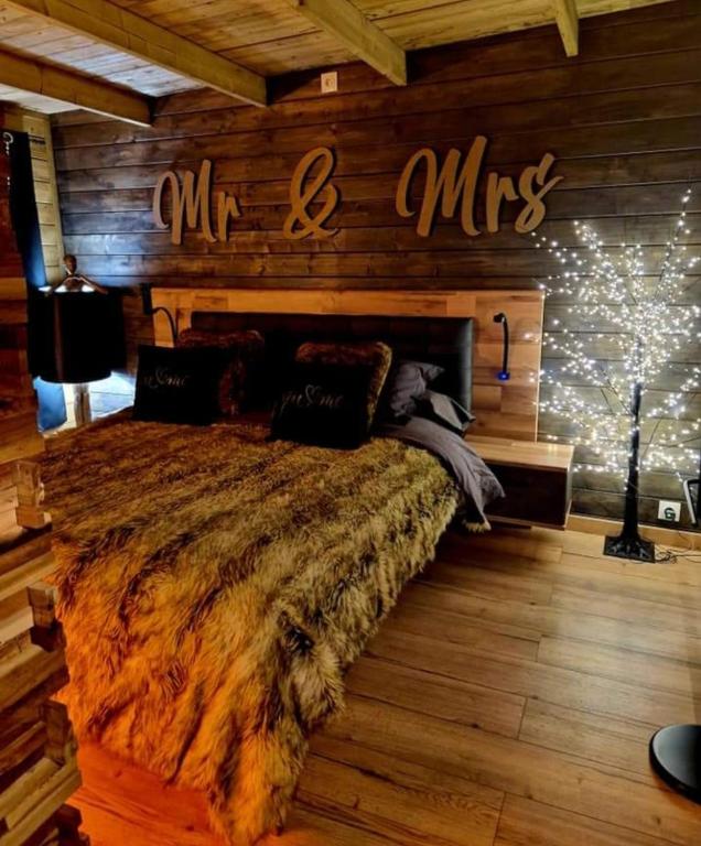 a bedroom with a large bed in a log cabin at A Loffre Zen in Loffre