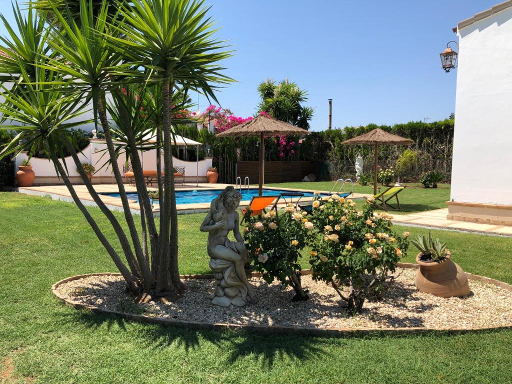 a statue of a cat standing next to a palm tree at Villa Salvatore in Aznalcázar