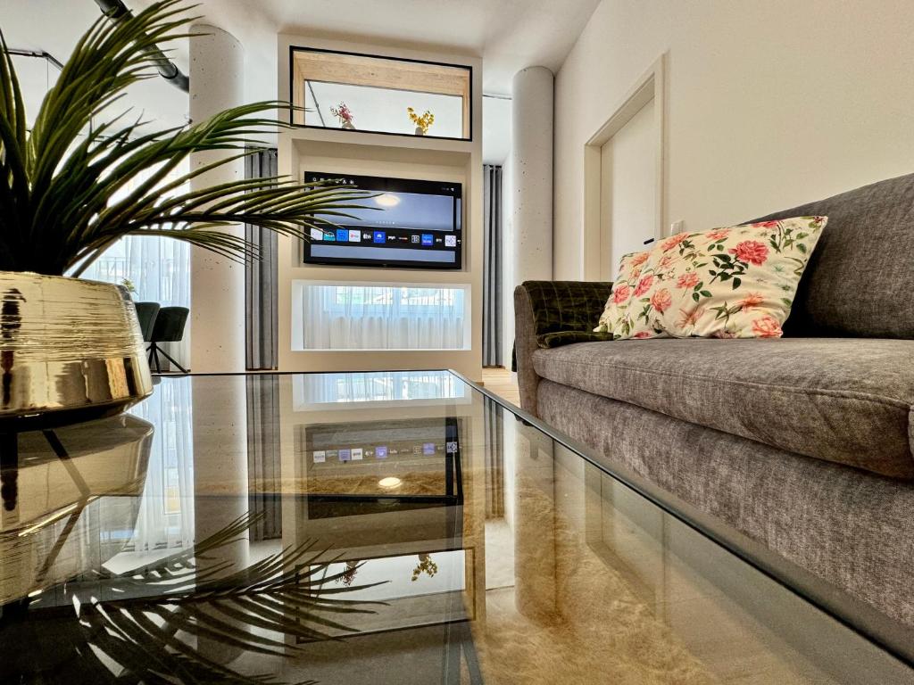 un soggiorno con tavolo in vetro e divano di The Loft a Gmunden