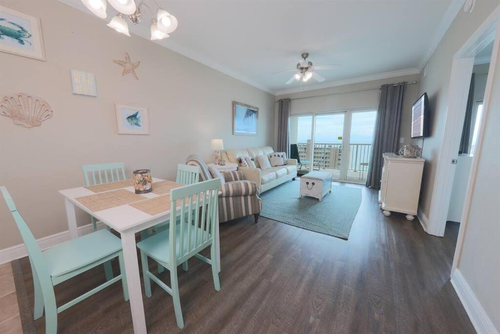 Una cocina y una sala de estar con una mesa y un sofá. en 10th Floor Crystal Tower 2 Bedroom Condo with 2 Outdoor Pools, Lazy River, Heated Indoor Pool, and Direct Beach Access, en Gulf Shores