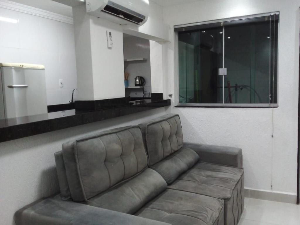 a living room with a couch and a large mirror at Apto 2 quartos Nucleo Bandeirante in Brasilia