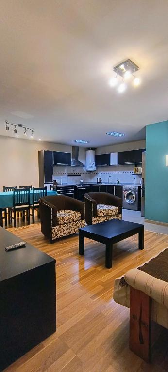 a living room with couches and tables in a room at Puerta Sur Apart in Malargüe