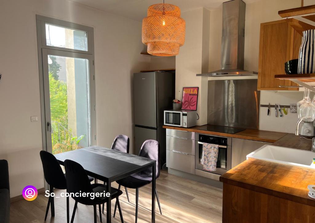 une cuisine avec une table et des chaises dans une cuisine dans l'établissement Chez Lucie, à Montpellier