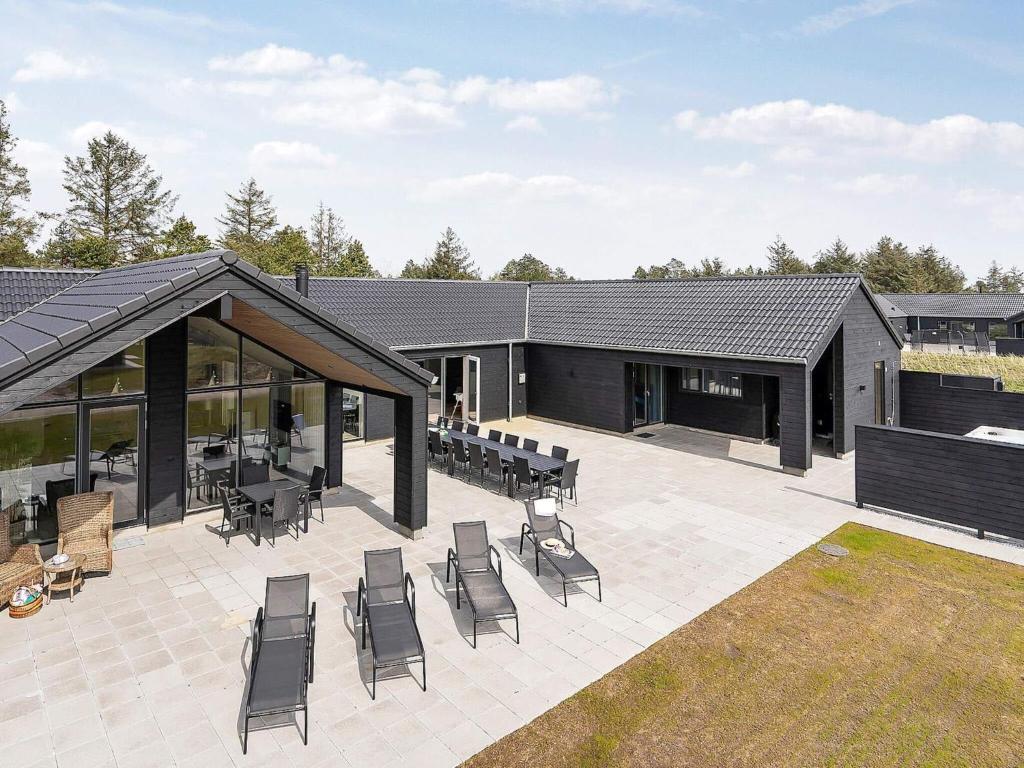 a patio with chairs and tables and a building at Luxury Retreat in Romo - By Traum Ferienwohnungen in Kongsmark