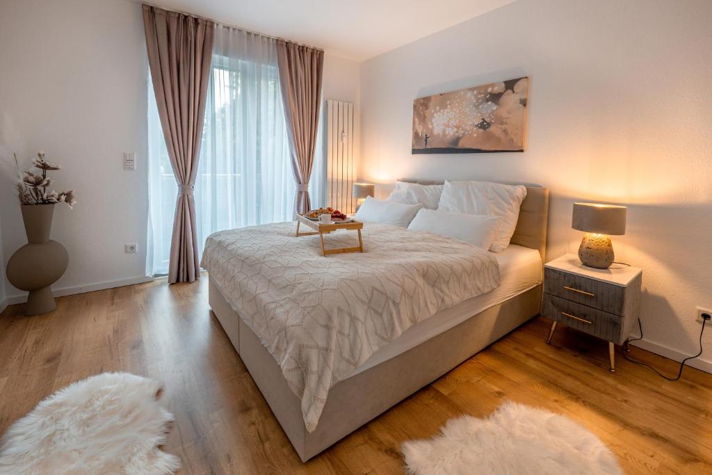 a bedroom with a large bed with a table on it at Traumhaftes Apartment -Balkon -Hängesessel -WiFi in Viersen