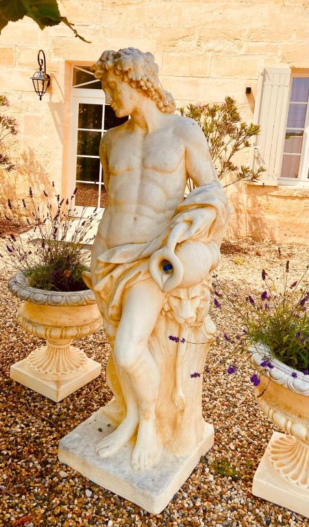 une statue d'une femme assise sur un vase dans l'établissement Clos Stella, à Mérignas