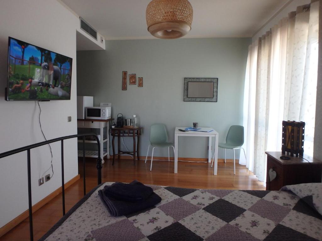 a living room with a bed and a table with chairs at Suite na Casa da Andreia in São Martinho do Porto